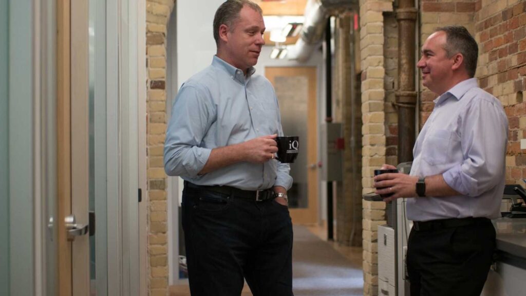 Two men drinking coffee in coworking space